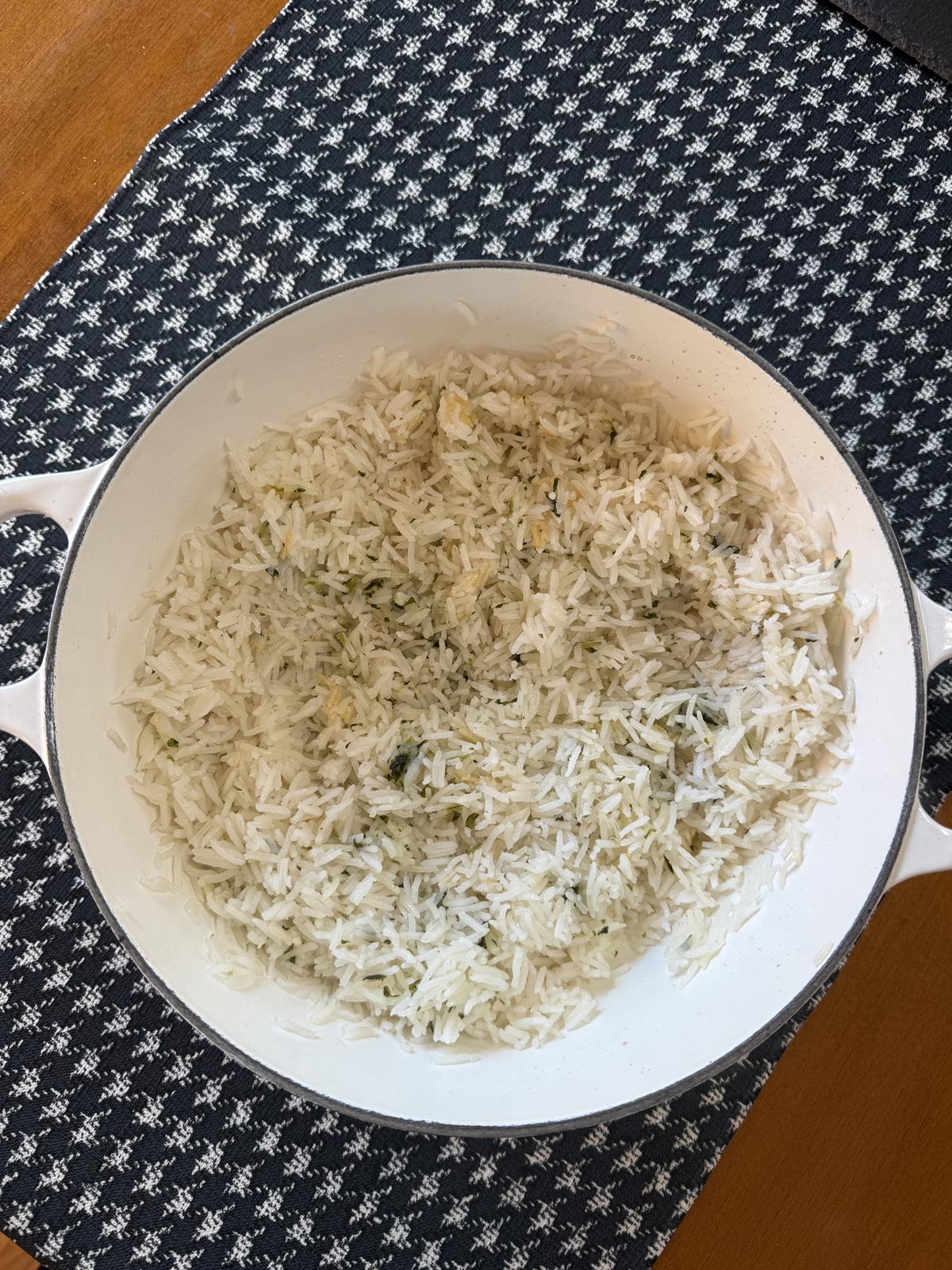 cilantro lime rice in white cast iron pan on black and white cloth