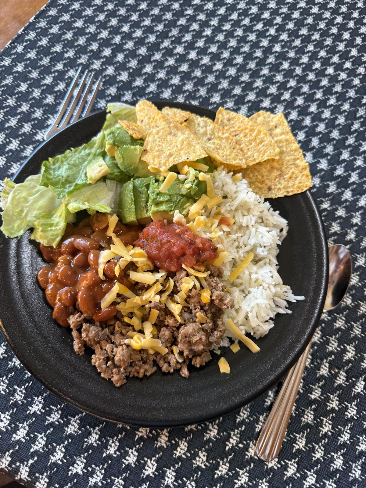 Cilantro Lime Rice with meat cheese beans and chips on black plate