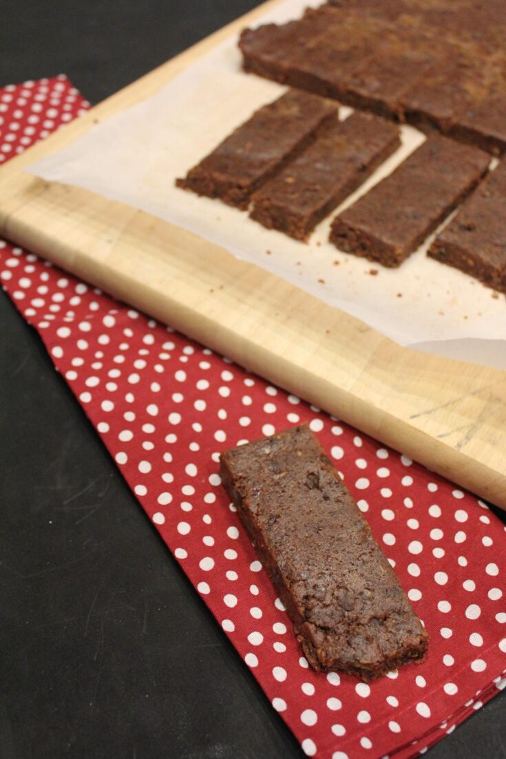 Homemade Nut Free Larabars on red and white napkin with bars on cutting board in background