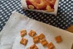 box of gluten free cheez it crackers on table with crackers on napkin