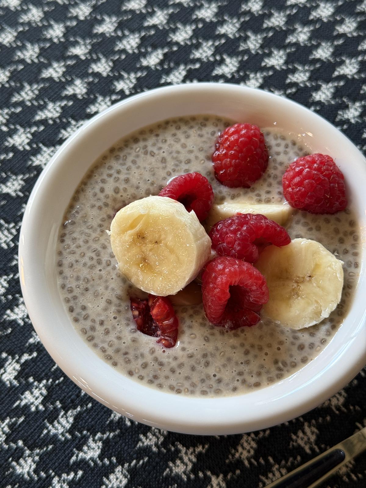 Peanut Butter and Jelly Chia Seed Pudding in white bowl with berries and bananas on top