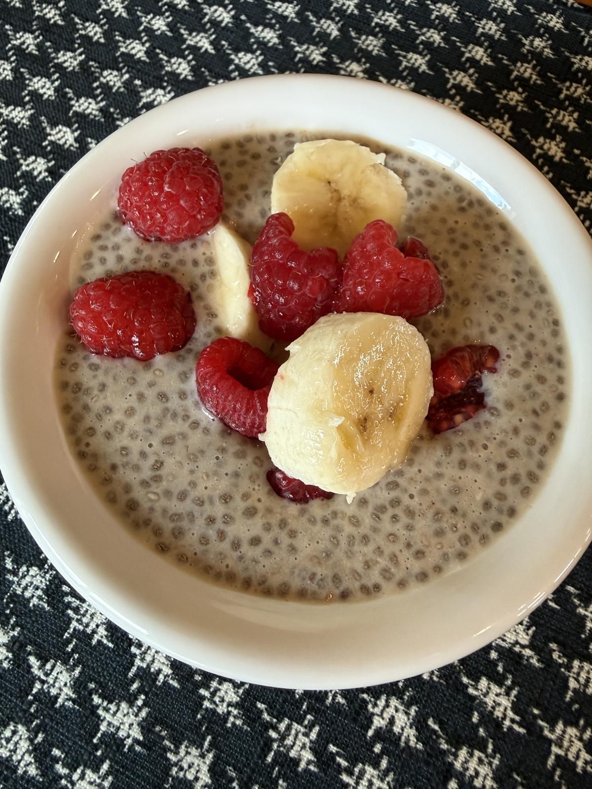 Peanut Butter and Jelly Chia Seed Pudding in white bowl with berries and bananas on top