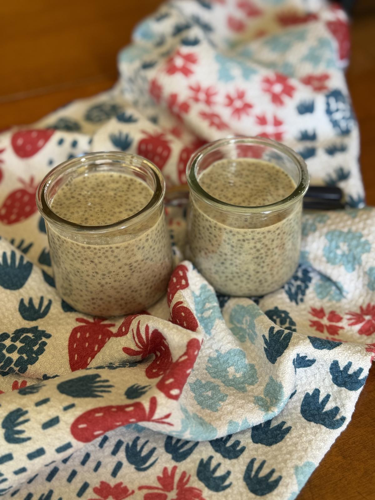 peanut butter and jelly chia seed pudding in glass jars on table with red white and blue napkin