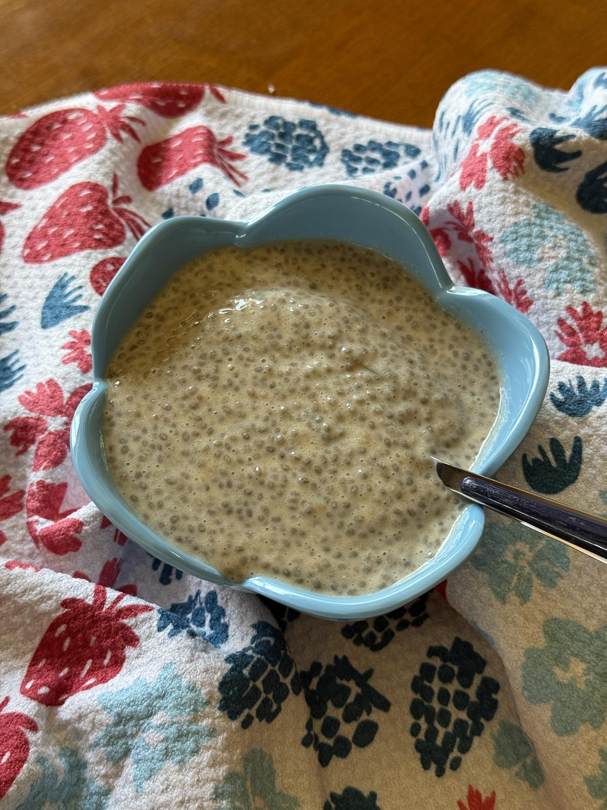 pb and j chia seed pudding in blue bowl with spoon on red white and blue napkin
