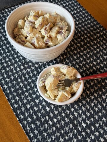old fashioned potato salad in white bowl with fork
