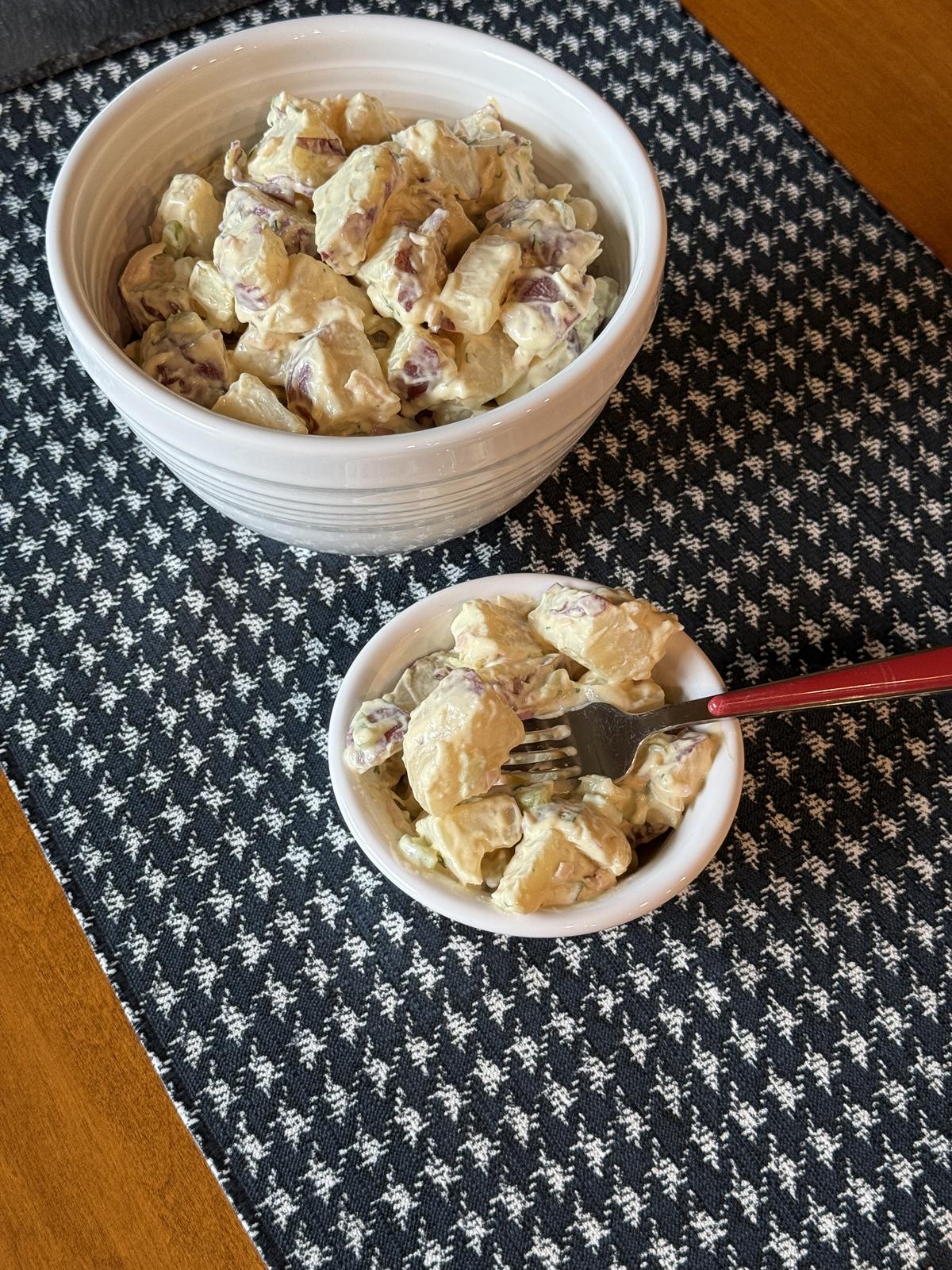 old fashioned potato salad in white bowl with fork