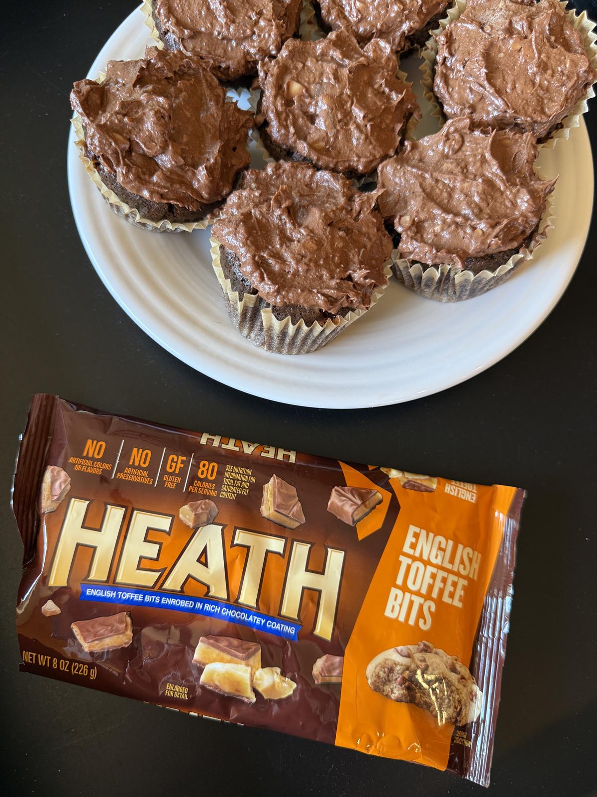 chocolate toffee cupcakes on white plate and package of heath bits in front on black background