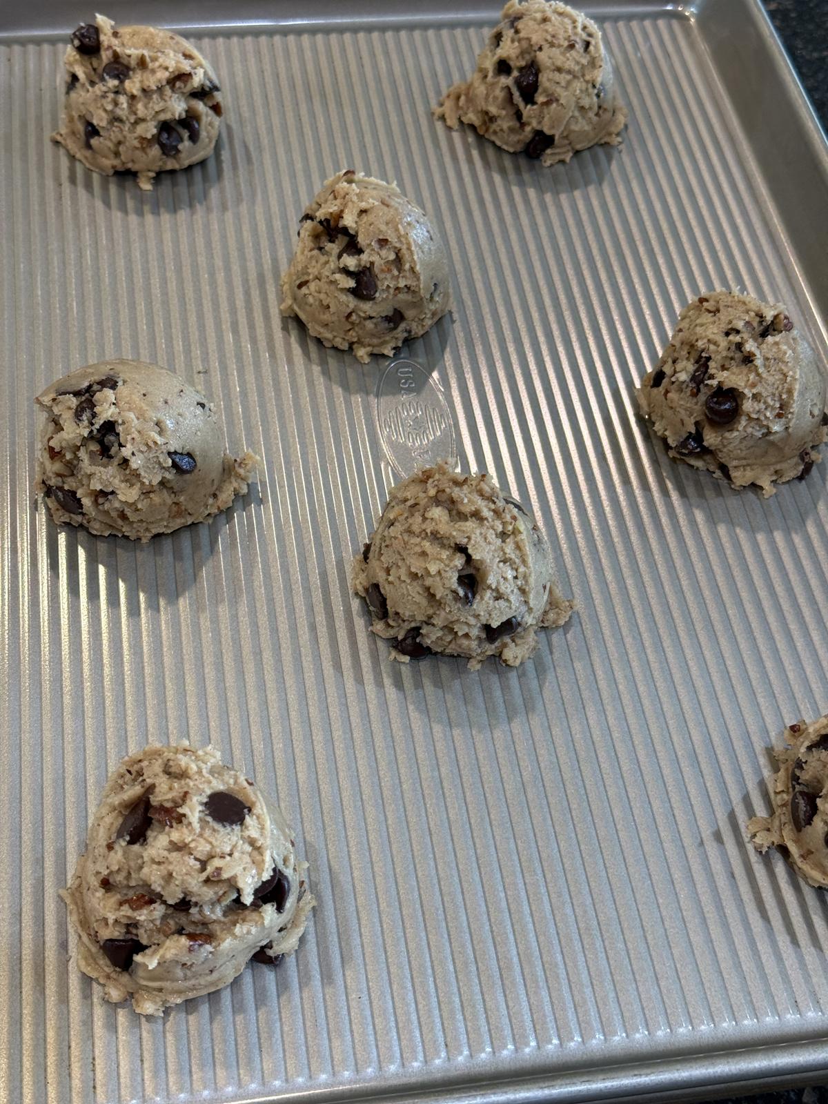 chocolate toffee pecan cookies unbaked on cookie sheet