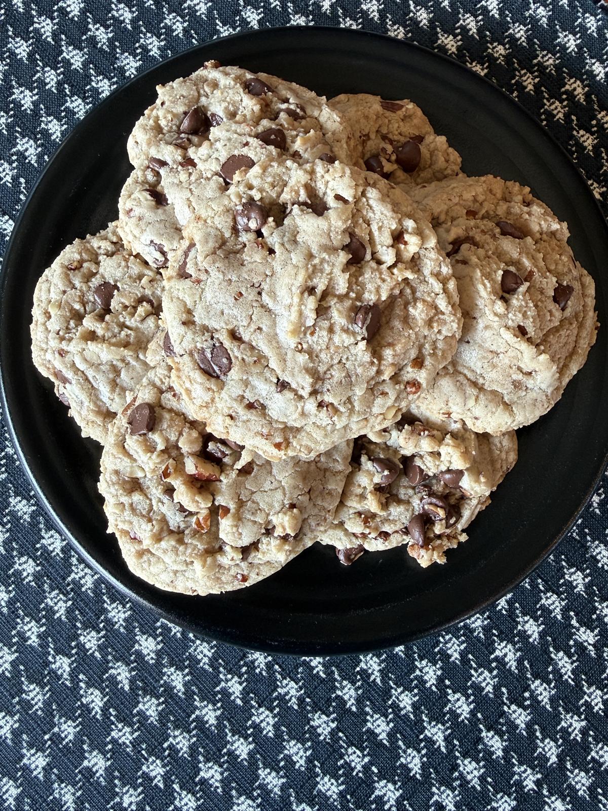 chocolate toffee pecan cookies on black plate